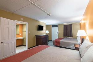 um quarto de hotel com uma cama e uma televisão em LoneStar Inn and Suites em Sherman
