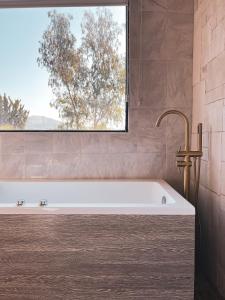 a bath tub in a bathroom with a window at Penthouse at Hotel Boutique Valle de Guadalupe in Valle de Guadalupe