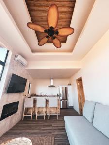 a living room with a ceiling fan and a couch at Penthouse at Hotel Boutique Valle de Guadalupe in Valle de Guadalupe