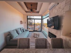 a living room with a couch and a tv at Penthouse at Hotel Boutique Valle de Guadalupe in Valle de Guadalupe