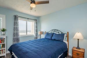 a blue bedroom with a bed and a window at Beach Therapy in Caswell Beach +62 photos