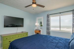 a bedroom with a bed and a window with the beach at Beach Therapy in Caswell Beach