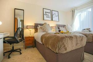 a bedroom with two beds and a desk and a chair at Lowndes House - Close to City Centre - Garden, Free Parking and Smart TV by Yoko Property in Milton Keynes