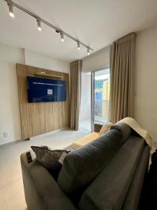 a living room with a couch and a large window at Stúdio Elegance Central - Av Itamar Franco in Juiz de Fora