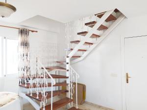 - un escalier blanc dans une chambre aux murs blancs dans l'établissement INMOGEST - Apartamento Mar Golondrinas - Parking free, à Benalmádena
