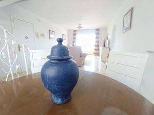 un vase bleu assis sur une table dans une pièce dans l'établissement INMOGEST - Apartamento Mar Golondrinas - Parking free, à Benalmádena