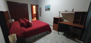 una camera con letto rosso e scrivania di Cómodo departamento a Papantla de Olarte