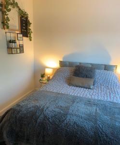 a bedroom with a bed with a blue comforter at BYRON SQUARE COTTAGE in Hucknall