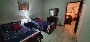 a hotel room with two beds and a mirror at Cómodo departamento in Papantla de Olarte