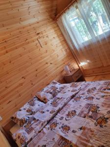 a bedroom with a bed in a wooden room at Village Story kuća za odmor Plavna 