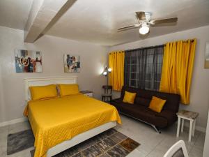 a bedroom with a yellow bed and a couch at The Castle in Philipsburg