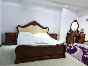 a bedroom with a large bed and two tables at PENSIUNEA LUXURY in Vama
