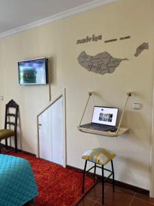 a room with a laptop on a shelf on the wall at Anchor House in Câmara de Lobos