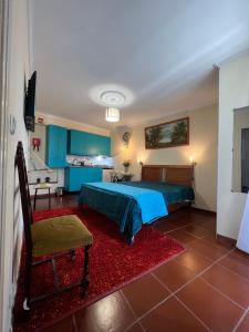 a bedroom with a blue bed and a red rug at Anchor House in Câmara de Lobos