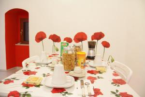 una mesa con un mantel con flores rojas. en La Rosa Blu 2, en Santeramo in Colle 33 fotos más