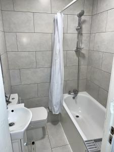 e bagno con servizi igienici, vasca e lavandino. di Modern 2 bed flat near Tottenham Hotspur Stadium a Edmonton
