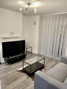 un soggiorno con divano e TV di Modern 2 bed flat near Tottenham Hotspur Stadium a Edmonton