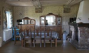 a dining room with a table and chairs and a fireplace at Gîte du Presbytère de L'Abbé L'Hermina in Saint-Martin-le-Gaillard