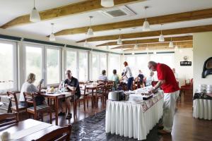 un hombre parado en una mesa en un restaurante en Galeria Pępowo, en Żukowo