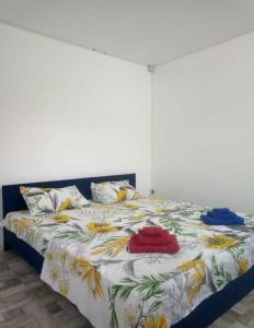 ein Bett mit bunter Bettwäsche und Kissen darauf in der Unterkunft Holiday Village in Eforie Nord