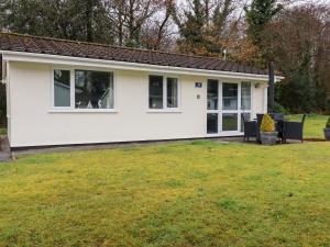 een wit huis met een hond in het raam bij Blue Sky Cottage in Liskeard