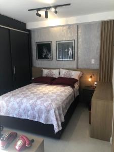 a bedroom with a large bed and a dresser at Studio Luxo Completo Independência 915- São Mateus in Juiz de Fora