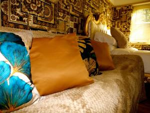 een bed met kussens in een slaapkamer bij Ultra Deluxe Versace Villa Hot Tub Cinema Room in Saffron Walden