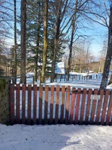 a fence in the snow with trees in the background at Villa di montagna sul cammino della Via degli Dei 