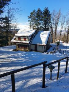una casa con un tetto innevato nella neve di Villa di montagna sul cammino della Via degli Dei 