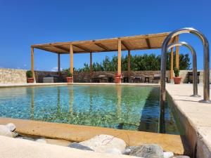 a swimming pool with a wooden pergola and a swimming pool at Villa Ypsi in Dhrámia