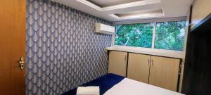 Habitación pequeña con cama y ventana en Ao Lado do Aeroporto com Ar Condicionado e vaga coberta, en Guarulhos