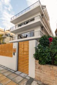 a large white house with a wooden gate at Skiathou 12 Contemporary Residences in Athens