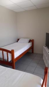 um quarto com 2 camas e uma televisão de ecrã plano em CasaLeon em Mejillones