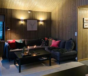 sala de estar con sofá y mesa de centro en Apartment with Electric car charger ski in out en Sjusjøen
