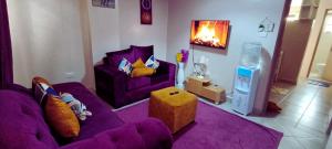 a living room with purple furniture and a purple couch at The Purple Gem Airbnb -South B- Oak South Apartments in Nairobi