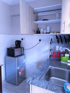 uma cozinha com um lavatório e uma bancada em The Purple Gem Airbnb -South B- Oak South Apartments em Nairobi
