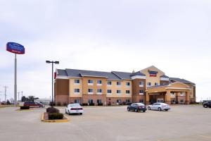 um grande edifício com carros estacionados num parque de estacionamento em Fairfield Inn & Suites Bloomington em Bloomington