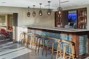 um bar com uma fila de bancos de bar em TownePlace Suites Columbus Hilliard em Hilliard