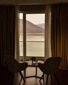 Hotel Cami في ديبار: غرفة بها كرسيين وطاولة أمام النافذة