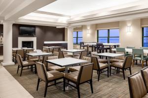 a restaurant with tables and chairs and a fireplace at Residence Inn New Rochelle in New Rochelle