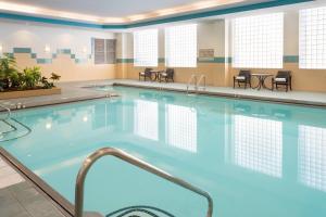 Marriott Anchorage Downtown في أنكوراج: حمام سباحة بمياه زرقاء في غرفة في الفندق