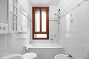a bathroom with a tub and a toilet and a sink at The Most Central In Venice [ San Marco Rialto ] in Venice