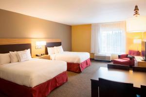 a hotel room with two beds and a chair and a desk at TownePlace Suites by Marriott Austin Round Rock in Round Rock
