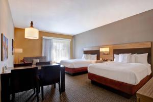 a hotel room with two beds and a desk at TownePlace Suites by Marriott Austin Round Rock in Round Rock