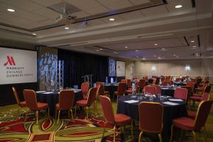 a conference room with tables and chairs and a screen at Hampton Inn & Suites Downers Grove Chicago in Downers Grove