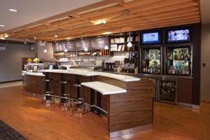 a bar in a restaurant with a counter and stools at Courtyard by Marriott Fayetteville in Fayetteville