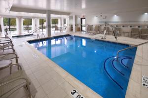 a large pool in a hotel with chairs and tables at Courtyard by Marriott Fayetteville in Fayetteville