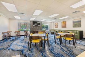 uma sala de conferências com mesas e cadeiras e uma televisão em Fairfield Inn & Suites by Marriott Chicago Naperville em Naperville