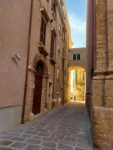 un callejón en un edificio antiguo con un arco en BETÌ en Taranto
