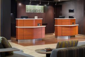 a lobby with wooden reception desks and chairs at Courtyard Charlotte SouthPark in Charlotte
